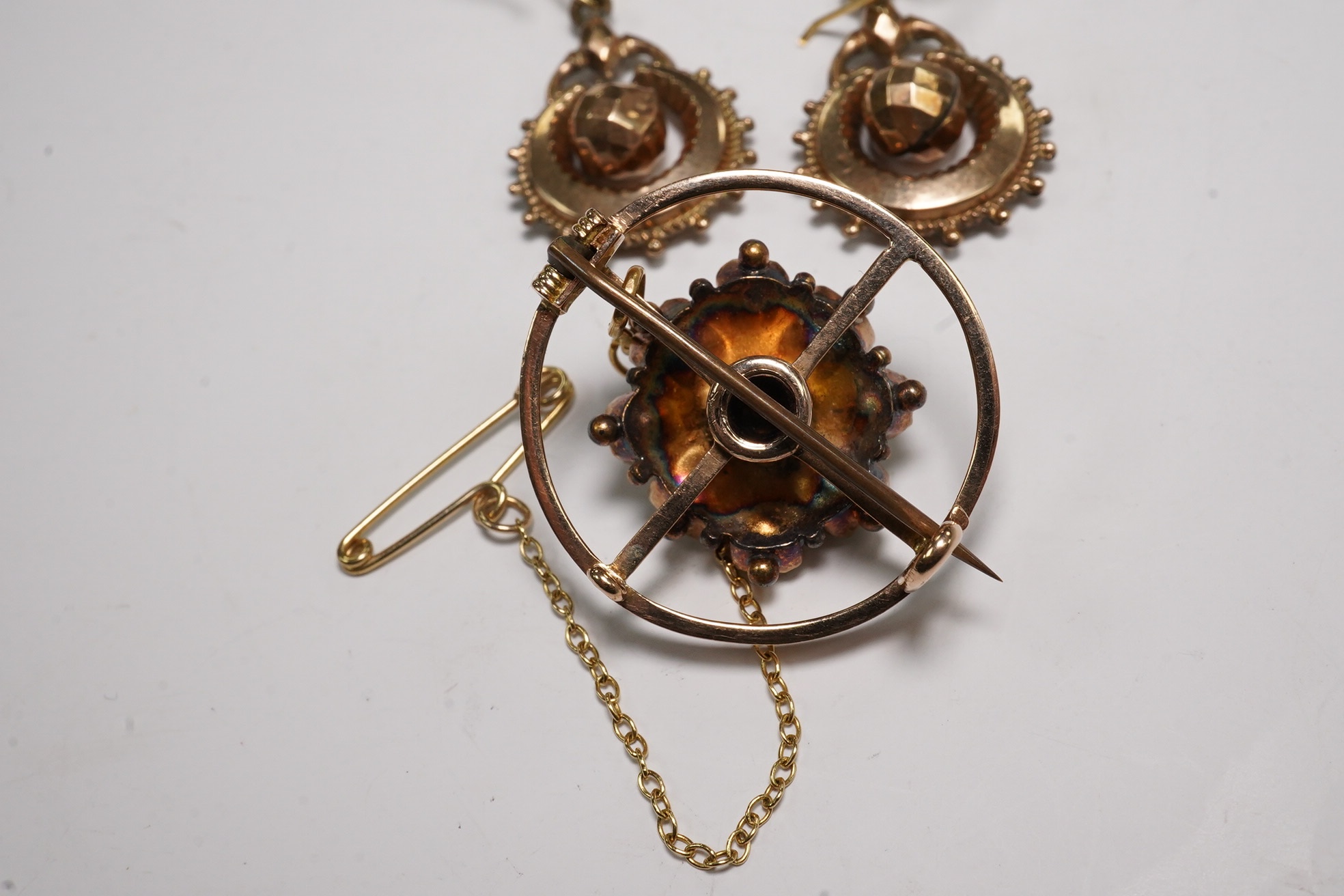 A pair of antique yellow metal drop earrings, 22mm and a yellow metal and two colour green gem set brooch. Condition - poor to fair